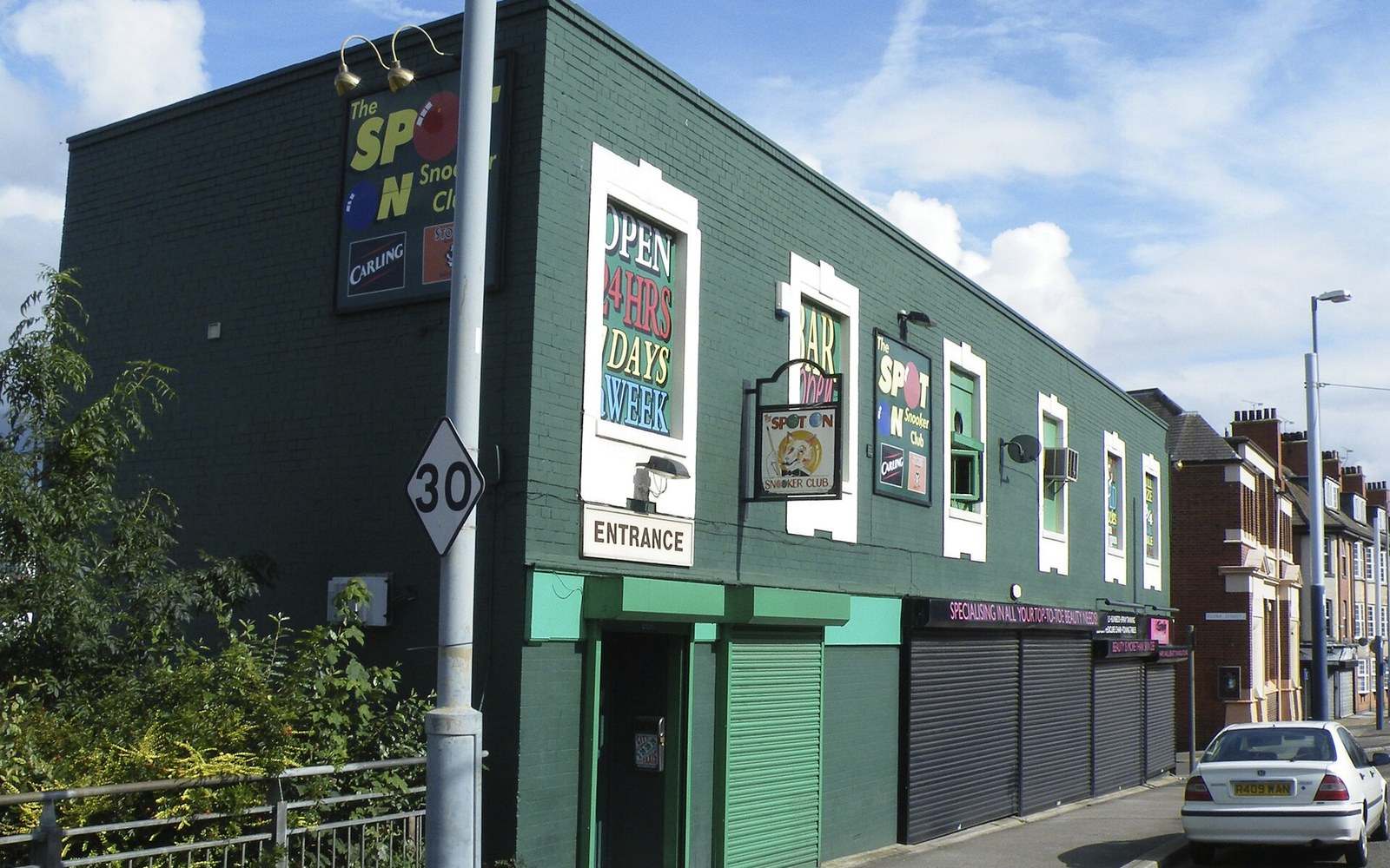 Green-painted building with the Spot On Snooker Club signage above shuttered street-level entrances